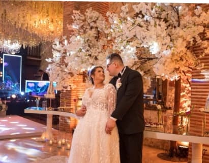 The couple kissing under white blossom trees