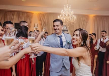 Wedding guests raising a toast with the couple, shot by a guest